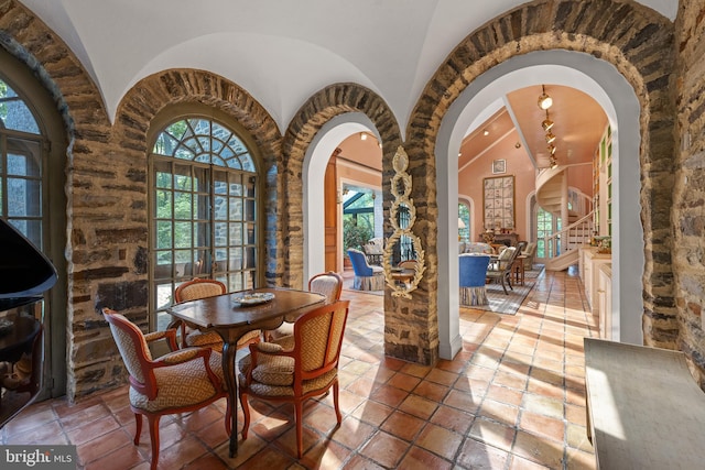 dining area with high vaulted ceiling and arched walkways