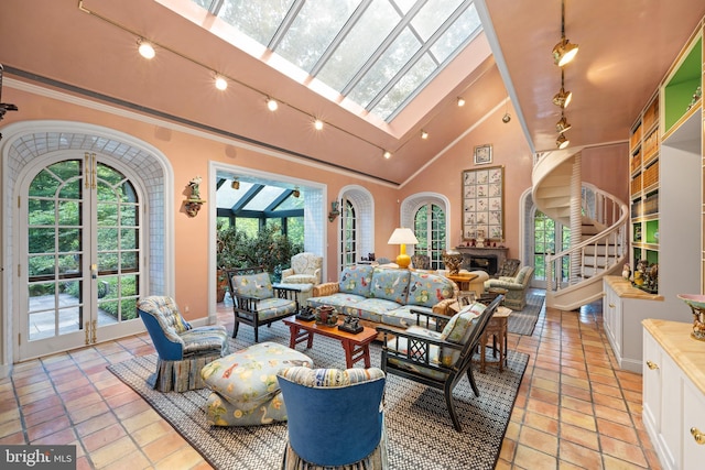 living area with arched walkways, french doors, a skylight, a fireplace, and stairway