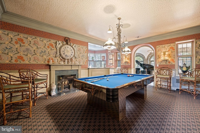 game room with a textured ceiling, a wainscoted wall, carpet floors, wallpapered walls, and crown molding