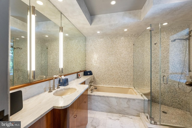 bathroom featuring marble finish floor, a garden tub, recessed lighting, a stall shower, and vanity