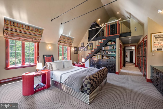 carpeted bedroom featuring high vaulted ceiling and baseboards