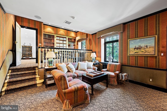 living area featuring visible vents and wallpapered walls