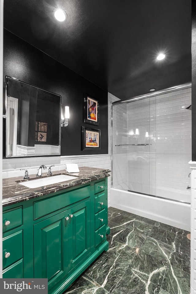 bathroom featuring shower / bath combination with glass door, a wainscoted wall, marble finish floor, vanity, and recessed lighting