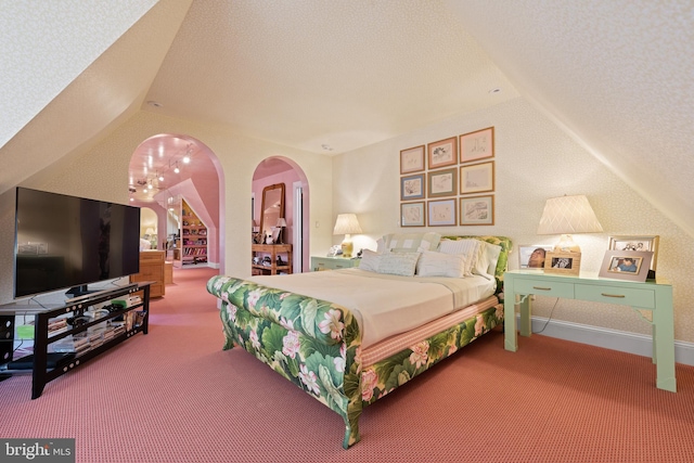 carpeted bedroom featuring arched walkways and vaulted ceiling