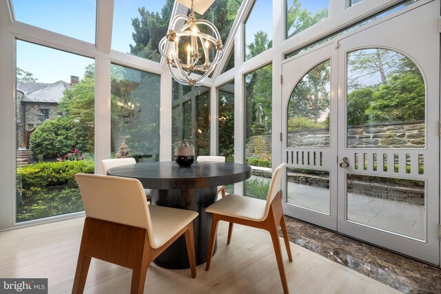 sunroom / solarium featuring a chandelier