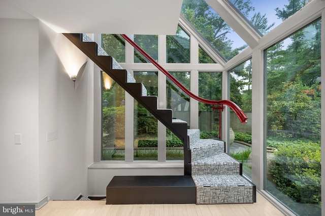 interior space featuring wood finished floors, plenty of natural light, and stairs