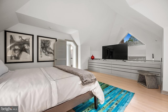 bedroom with lofted ceiling and wood finished floors