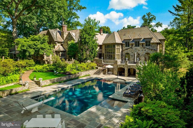 pool with stairway, a deck, and a patio