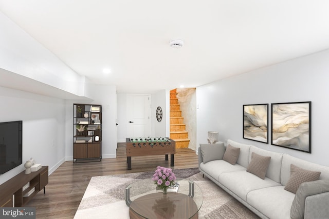 living room featuring baseboards, stairway, and wood finished floors