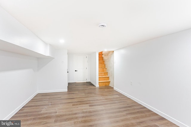 interior space featuring baseboards, light wood finished floors, and stairs