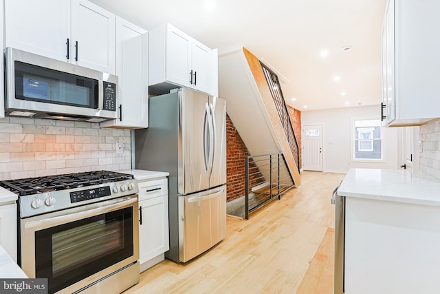 kitchen featuring stainless steel appliances, recessed lighting, light wood-style flooring, decorative backsplash, and white cabinets