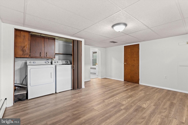 laundry room featuring light wood-style floors, cabinet space, and baseboards