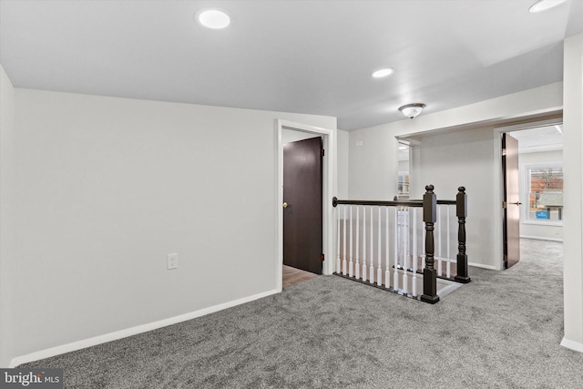 carpeted spare room featuring baseboards and recessed lighting