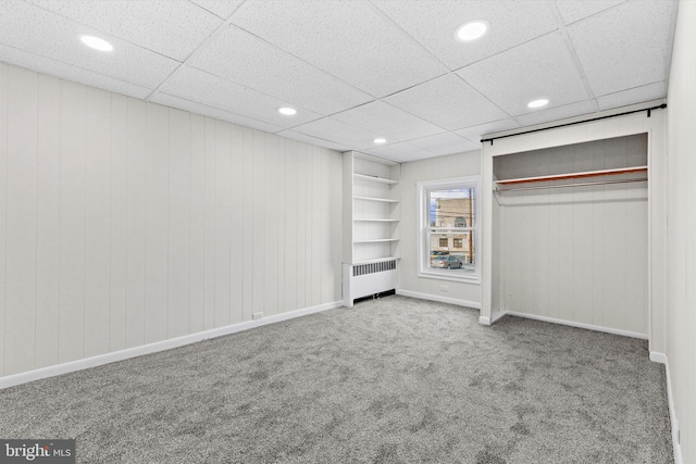 unfurnished bedroom with baseboards, radiator heating unit, carpet floors, a closet, and recessed lighting