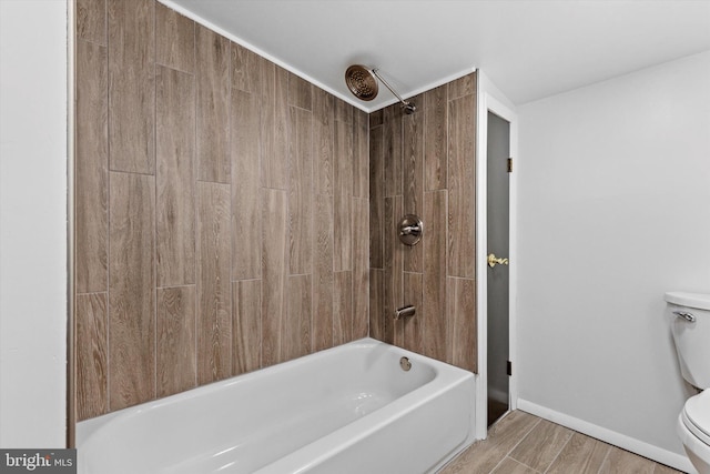 bathroom with toilet, baseboards, and shower / bathtub combination