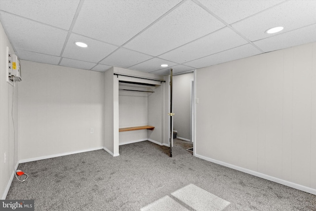 unfurnished bedroom with a paneled ceiling, recessed lighting, carpet flooring, baseboards, and a closet