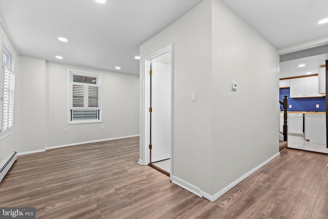 hallway featuring recessed lighting, baseboards, and wood finished floors