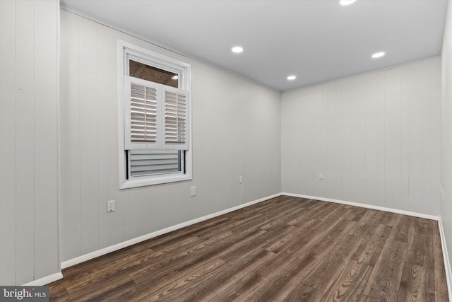 empty room featuring dark wood-style floors, baseboards, and recessed lighting