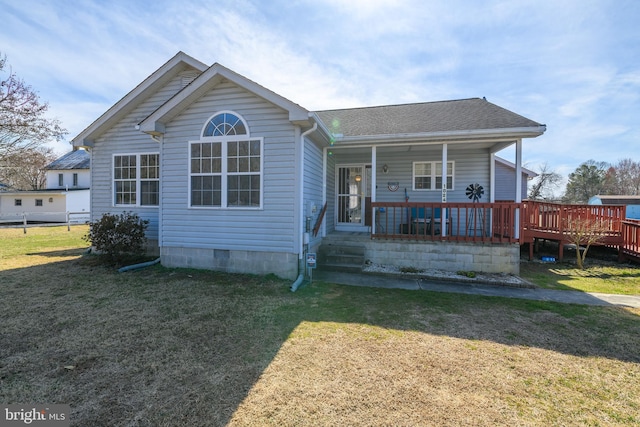 view of front of house featuring covered porch, roof with shingles, and a front lawn