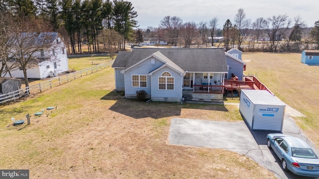 view of front of house with a deck, fence, roof with shingles, a front yard, and crawl space