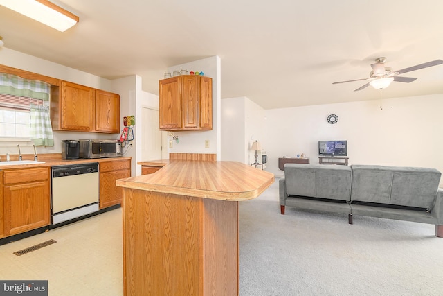 kitchen featuring visible vents, a ceiling fan, open floor plan, a peninsula, and white dishwasher