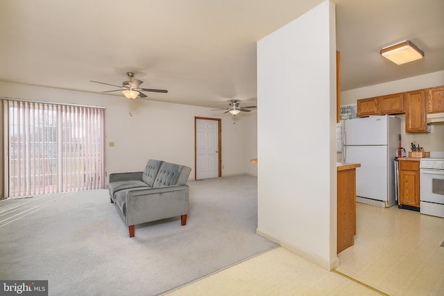 living area with light carpet, light floors, and ceiling fan