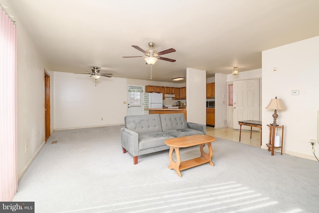 living area with a ceiling fan, baseboards, and light carpet