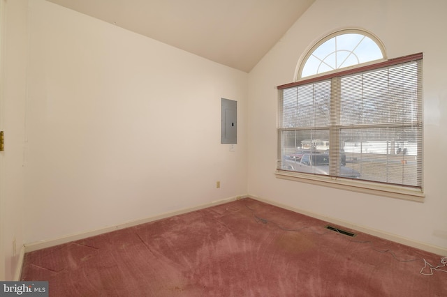 empty room featuring visible vents, electric panel, baseboards, carpet, and lofted ceiling