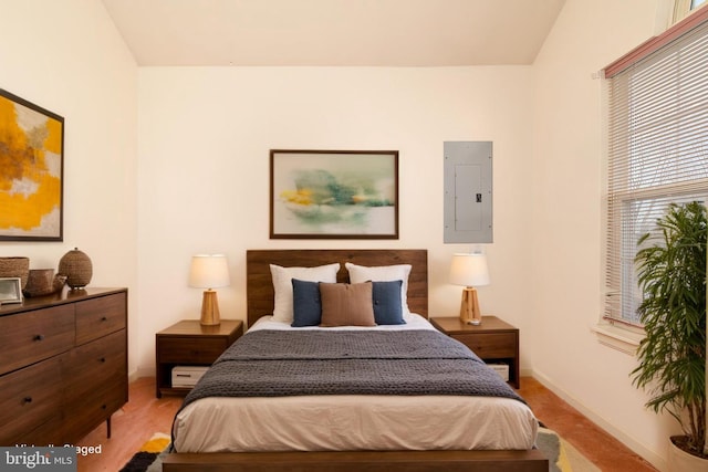 bedroom featuring electric panel and baseboards