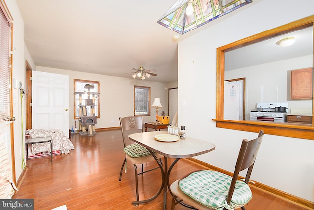 dining room with baseboards, wood finished floors, and a ceiling fan