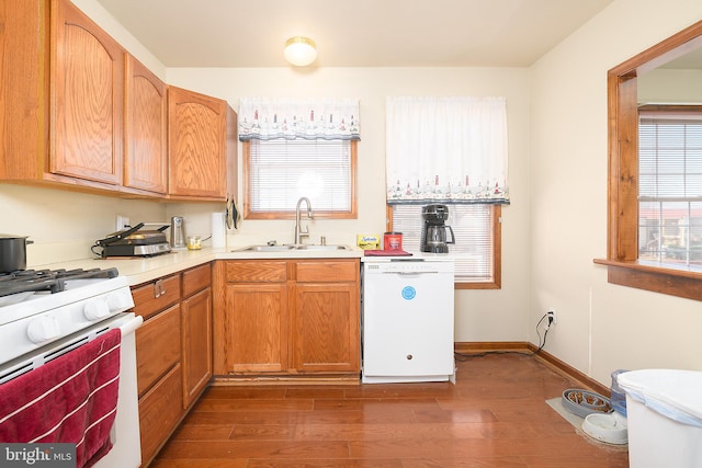 kitchen with dark wood-style flooring, white appliances, light countertops, and a sink