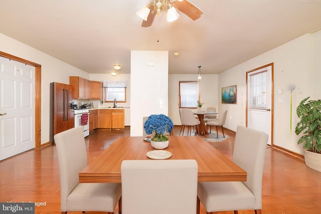 dining space featuring baseboards, dark wood-style flooring, and a ceiling fan