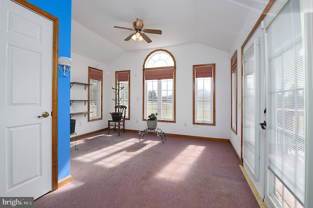 interior space featuring ceiling fan, baseboards, lofted ceiling, and carpet floors