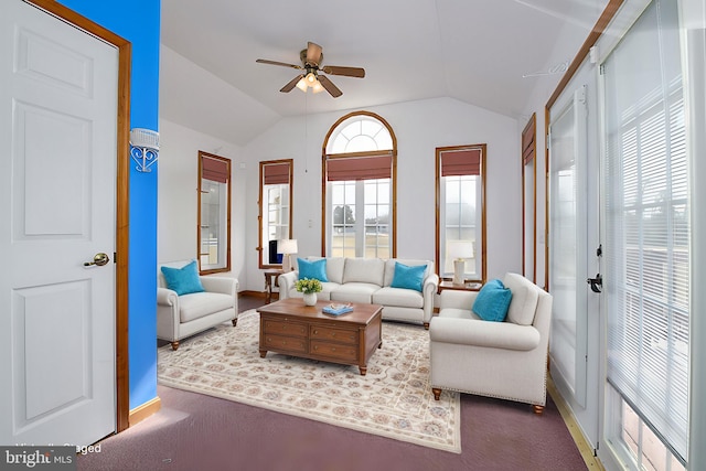 living room featuring baseboards, lofted ceiling, and a ceiling fan