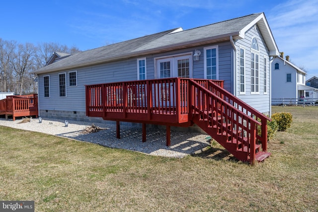 rear view of house with a lawn and a wooden deck