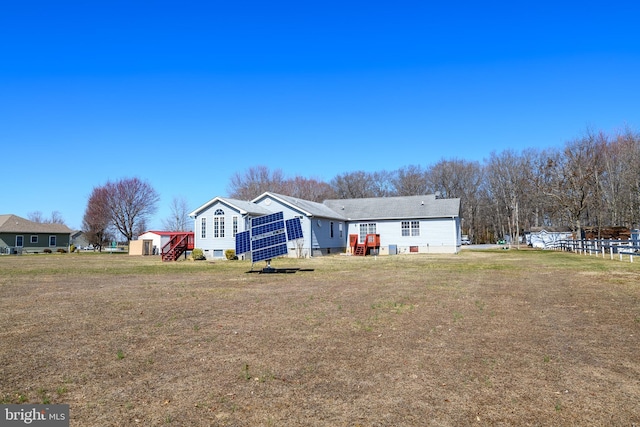 rear view of property featuring crawl space and solar panels