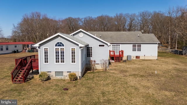 rear view of property featuring fence, roof with shingles, a yard, crawl space, and central air condition unit