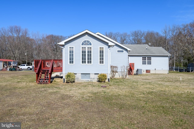 rear view of house featuring crawl space, a lawn, and a deck