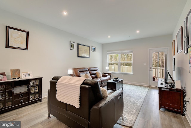 living area with baseboards, light wood finished floors, and recessed lighting