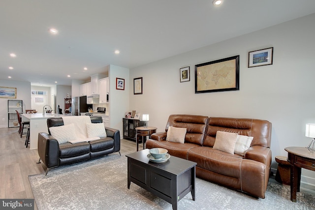 living room with light wood-type flooring and recessed lighting