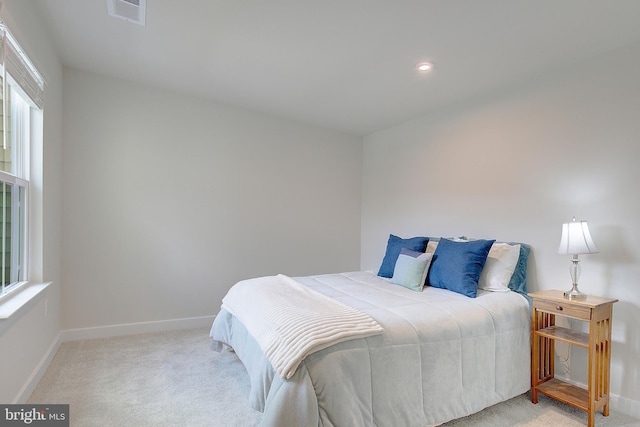 carpeted bedroom featuring baseboards, multiple windows, visible vents, and recessed lighting