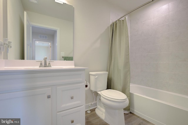 full bathroom with visible vents, toilet, shower / bath combo with shower curtain, vanity, and wood finished floors