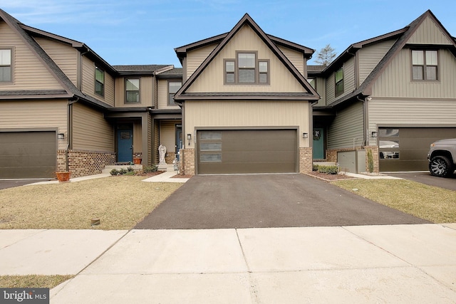 view of front of property with a garage, driveway, and brick siding