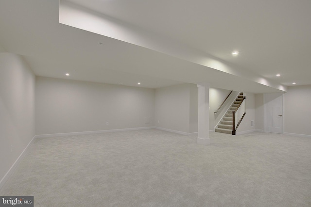 finished basement featuring recessed lighting, light carpet, stairway, and baseboards