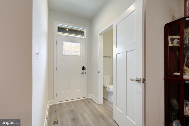 doorway to outside with visible vents, light wood-style flooring, and baseboards