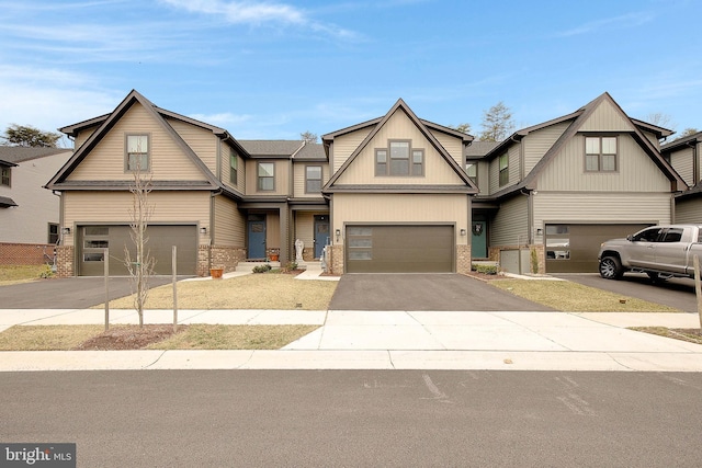 view of front of house featuring a garage, aphalt driveway, and brick siding