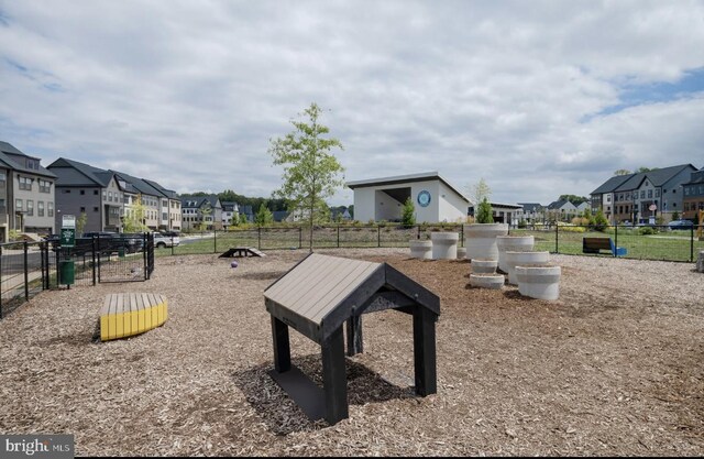 view of playground featuring a residential view and fence