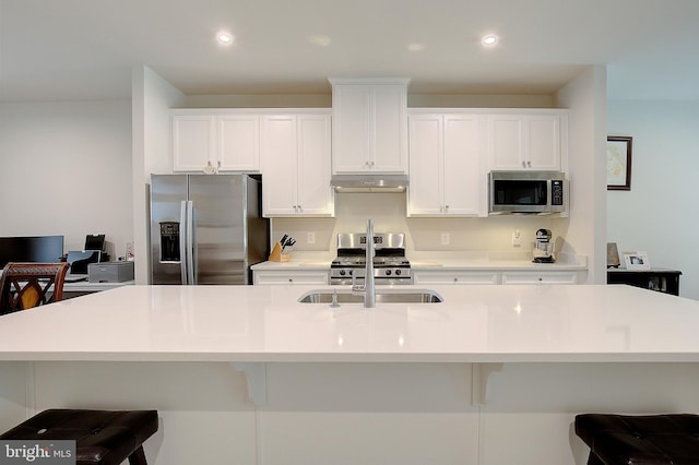 kitchen with appliances with stainless steel finishes, recessed lighting, white cabinetry, and under cabinet range hood