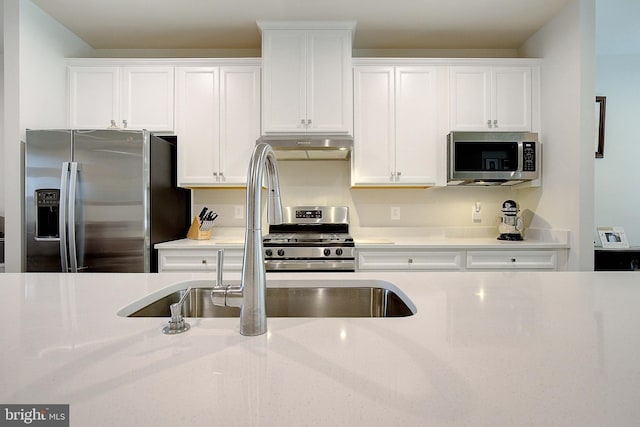 kitchen featuring under cabinet range hood, appliances with stainless steel finishes, and white cabinets