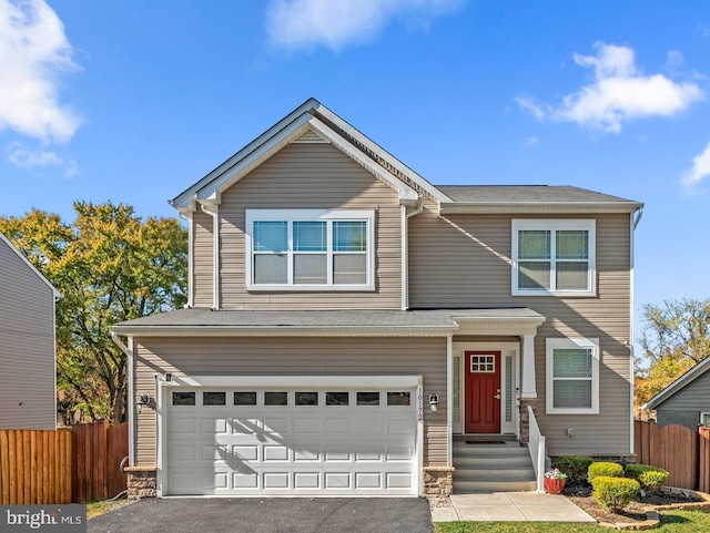 traditional home featuring a garage, fence, and aphalt driveway